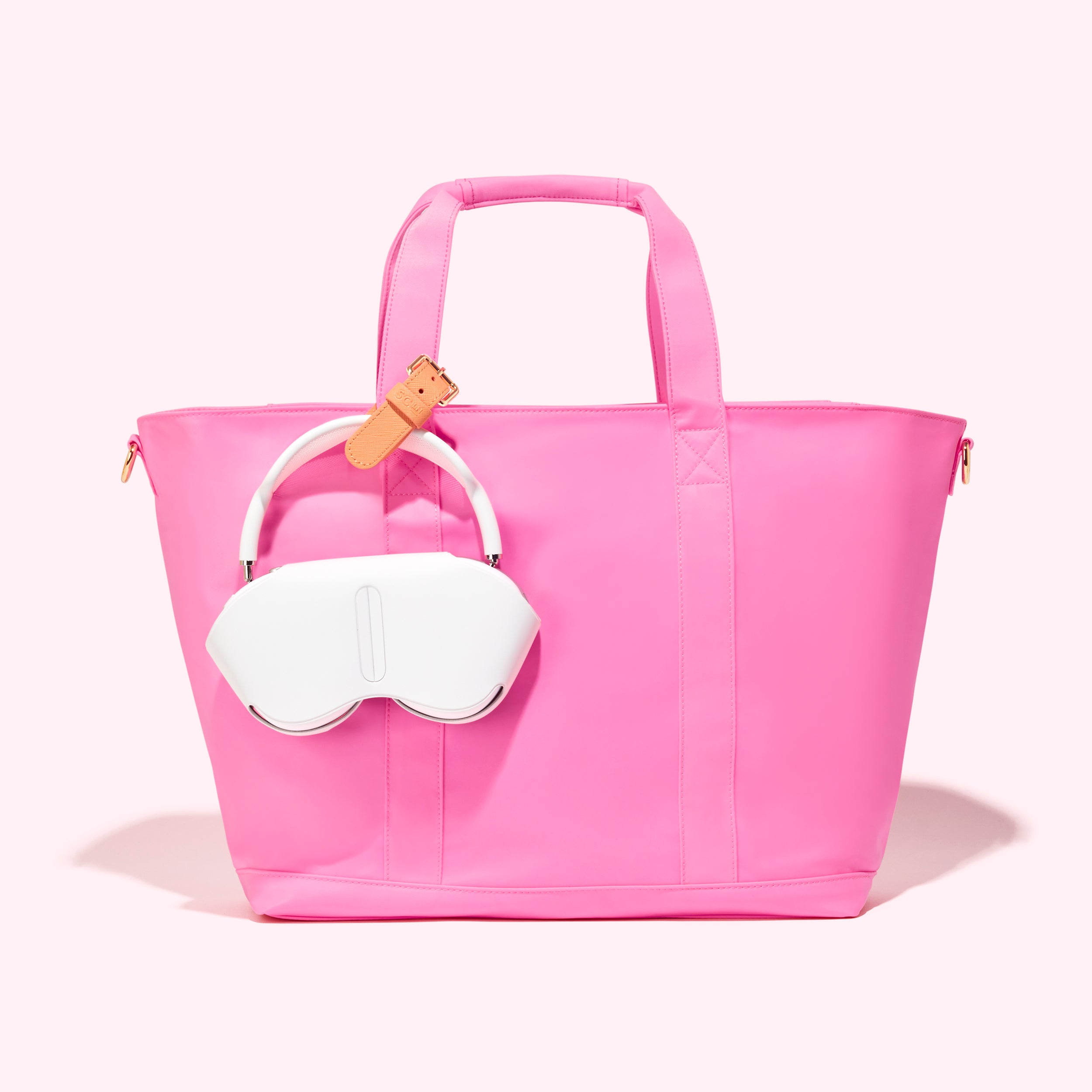Pink tote bag with white sleep mask on a light pink background